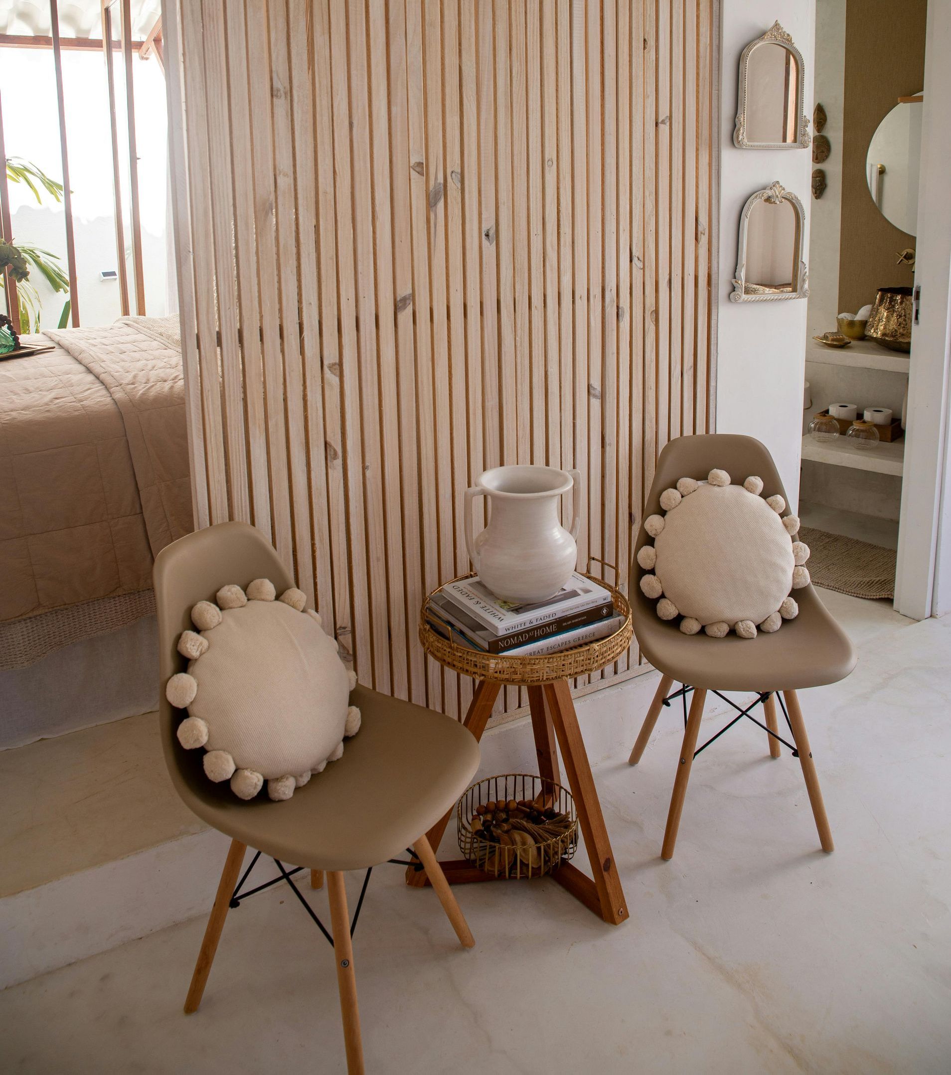 A room with two chairs and a table with a vase on top of it