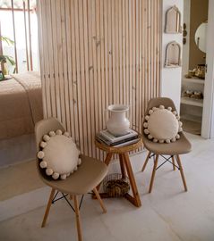A room with two chairs and a table with a vase on top of it