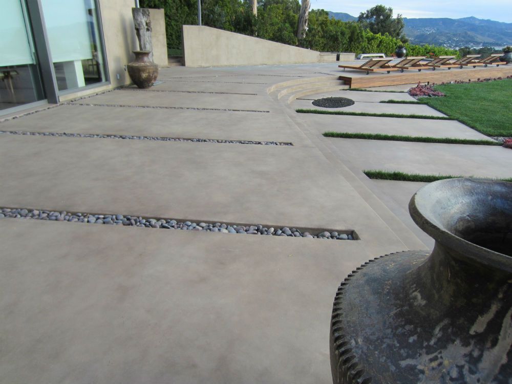 A circular concrete patio is being built in front of a house.