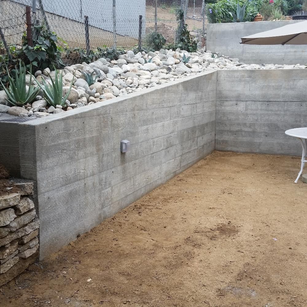 Waypoint Concrete poured a smooth concrete retaining wall with gravel backfill in a yard in Eagle, Idaho.