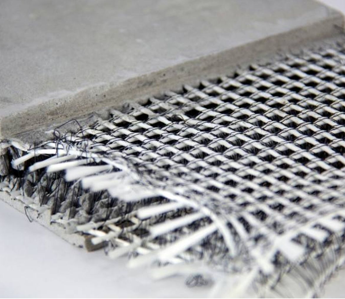 A close up of a piece of metal and a piece of concrete on a table.