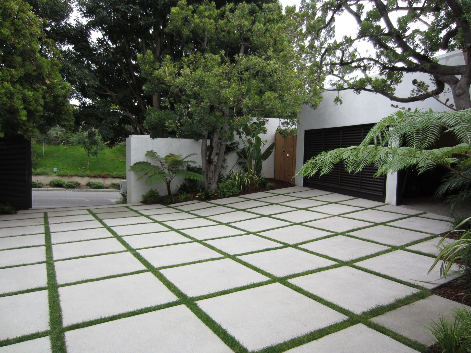 Waypoint Concrete completed a square grid-style driveway using pavers and turf infill in Eagle, Idaho.
