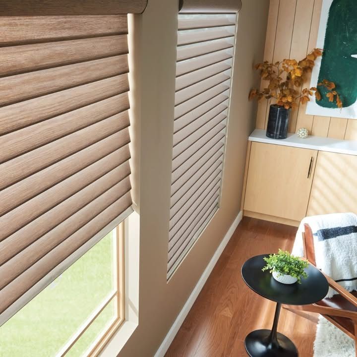 Interior room with brown blinds, a small table, and a decorative cabinet.
