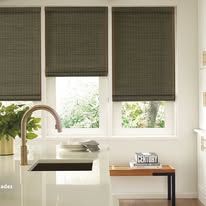 Kitchen with open blinds. Sink, faucet, and small wooden table.