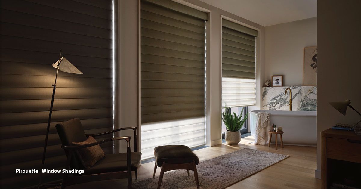 Interior room with closed blinds, natural light, chair, ottoman, and floor lamp.