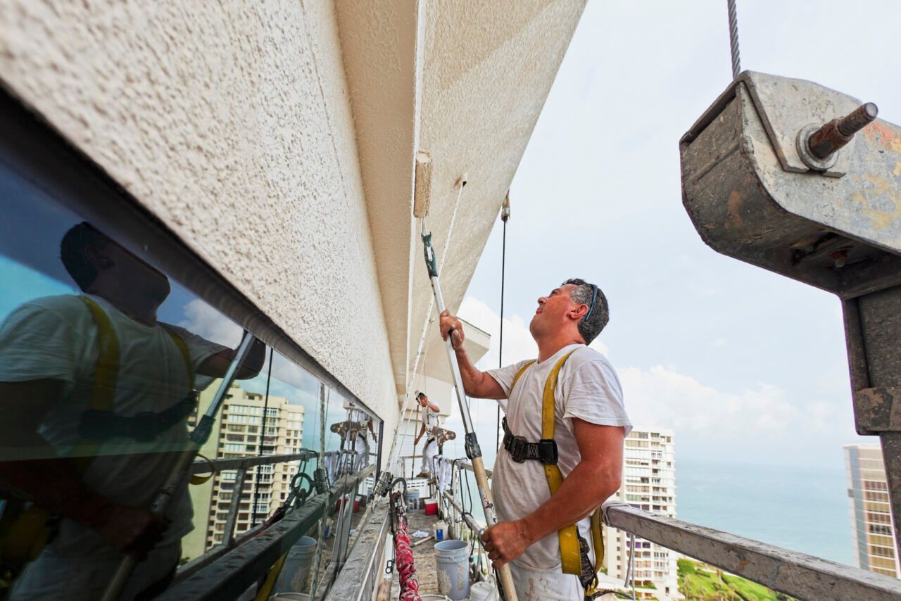 A man is painting the side of a building.