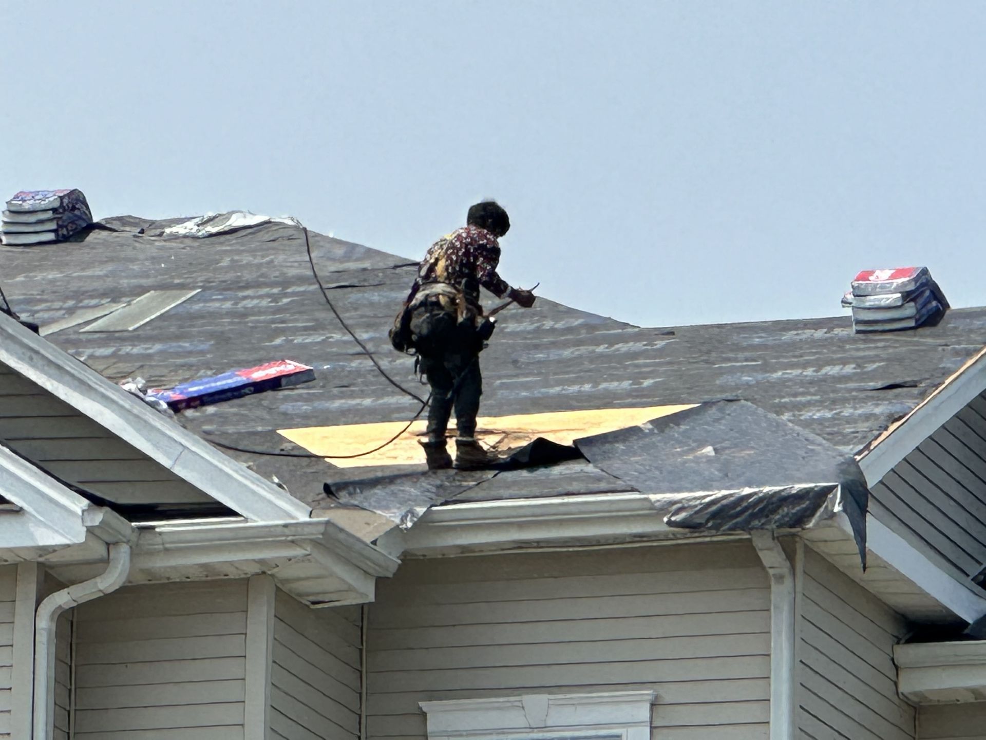 A man is working on the roof of a house.