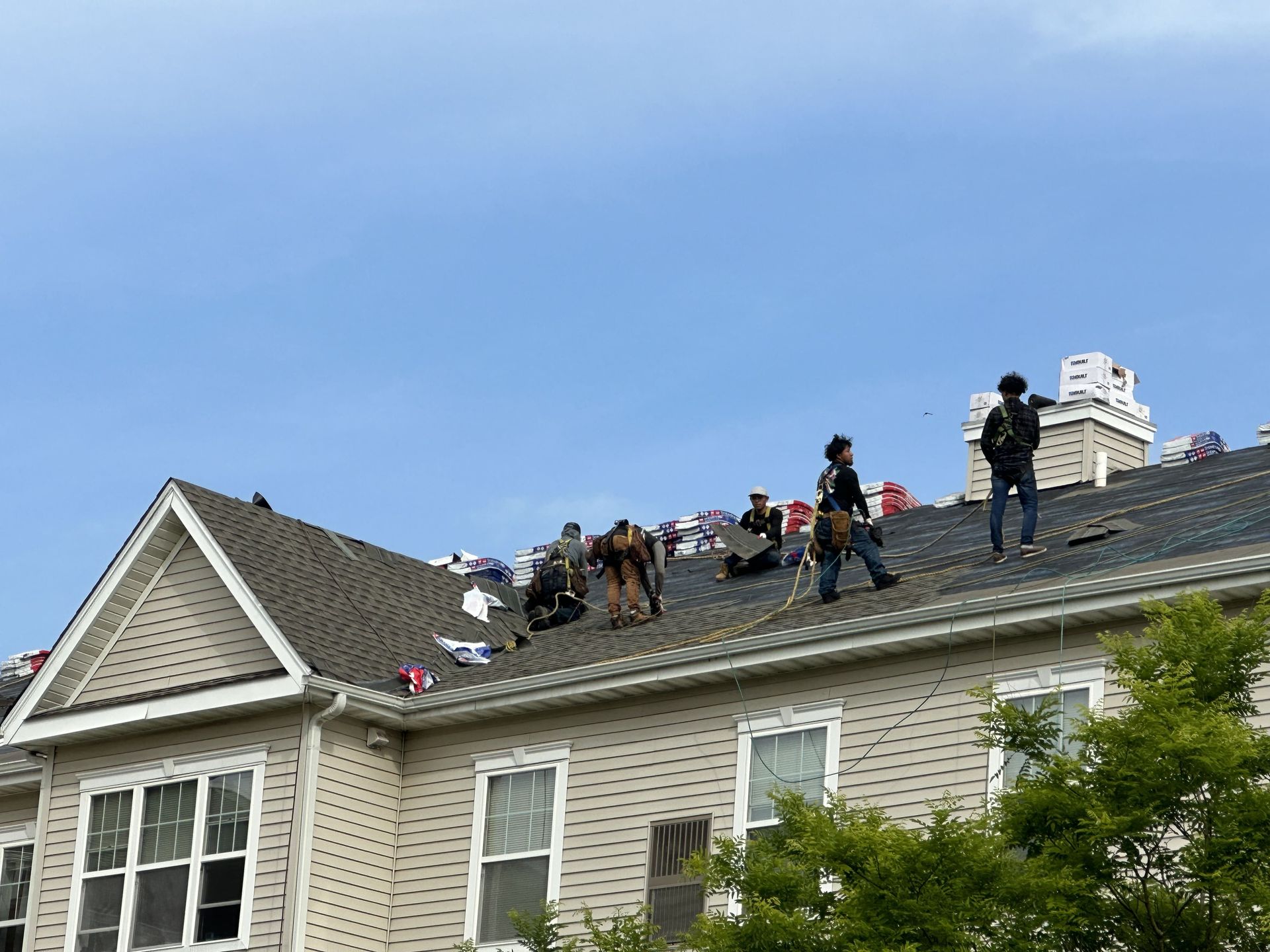 A house with several men repairing the roof.