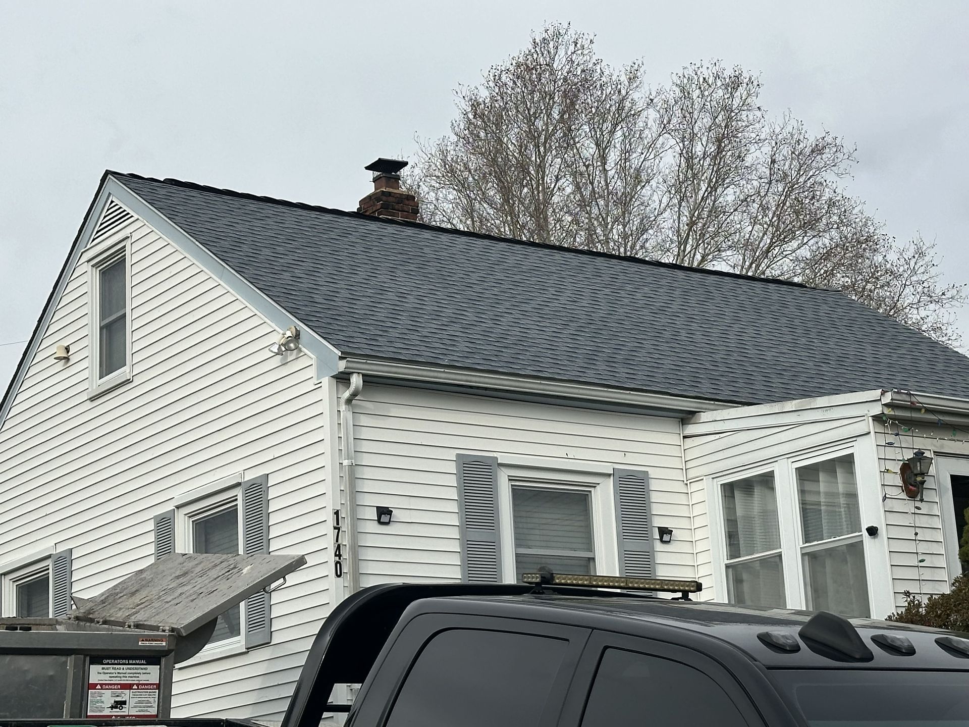 A white house with a black truck parked in front of it.