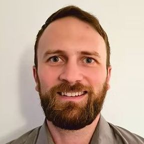 A man with a beard and mustache is smiling for the camera.