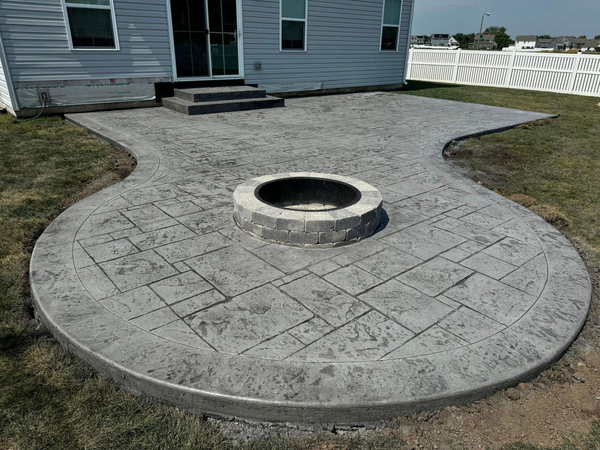 An image of a concrete patio with a firepit by cementrix concrete.