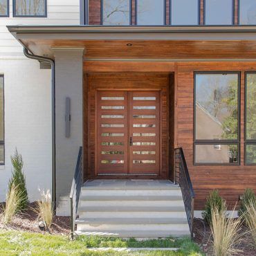 The front of a house with a wooden door and stairs.