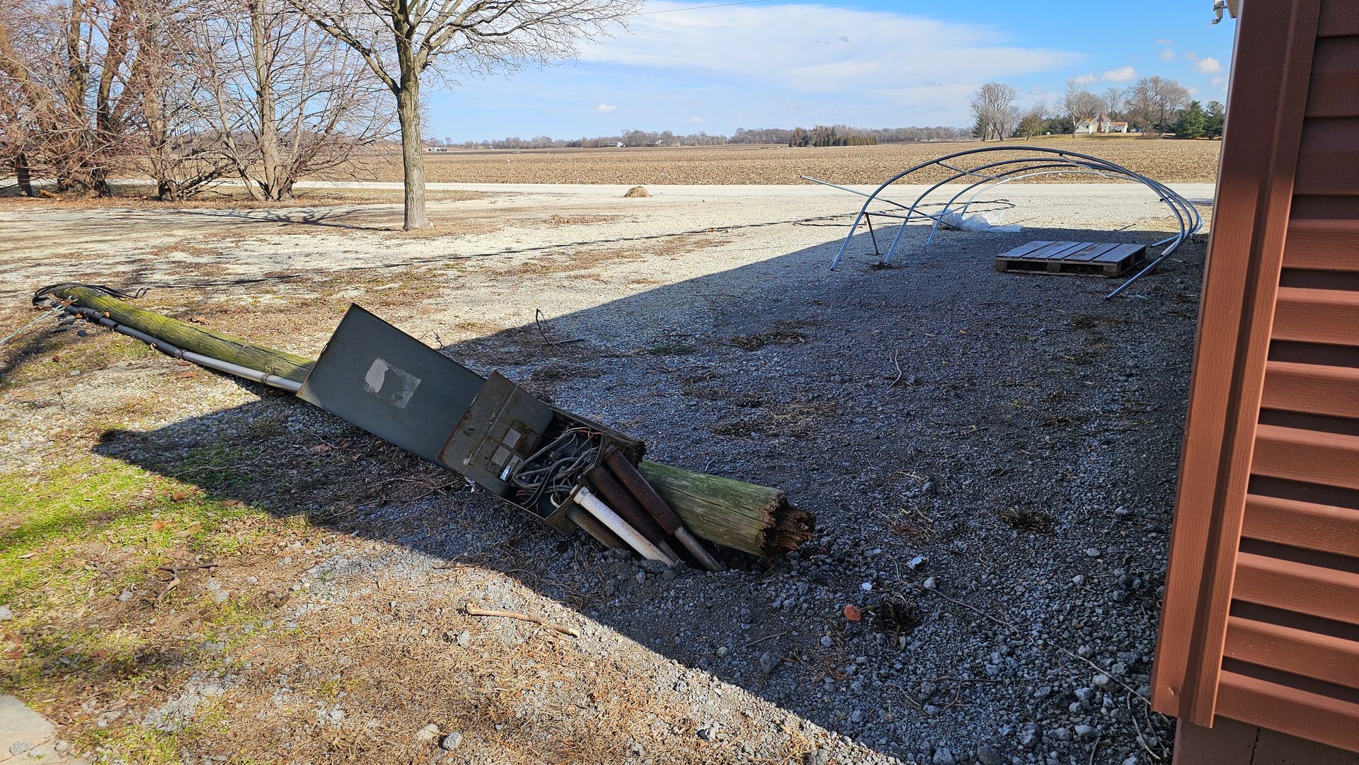 A piece of wood is laying on the ground next to a building.