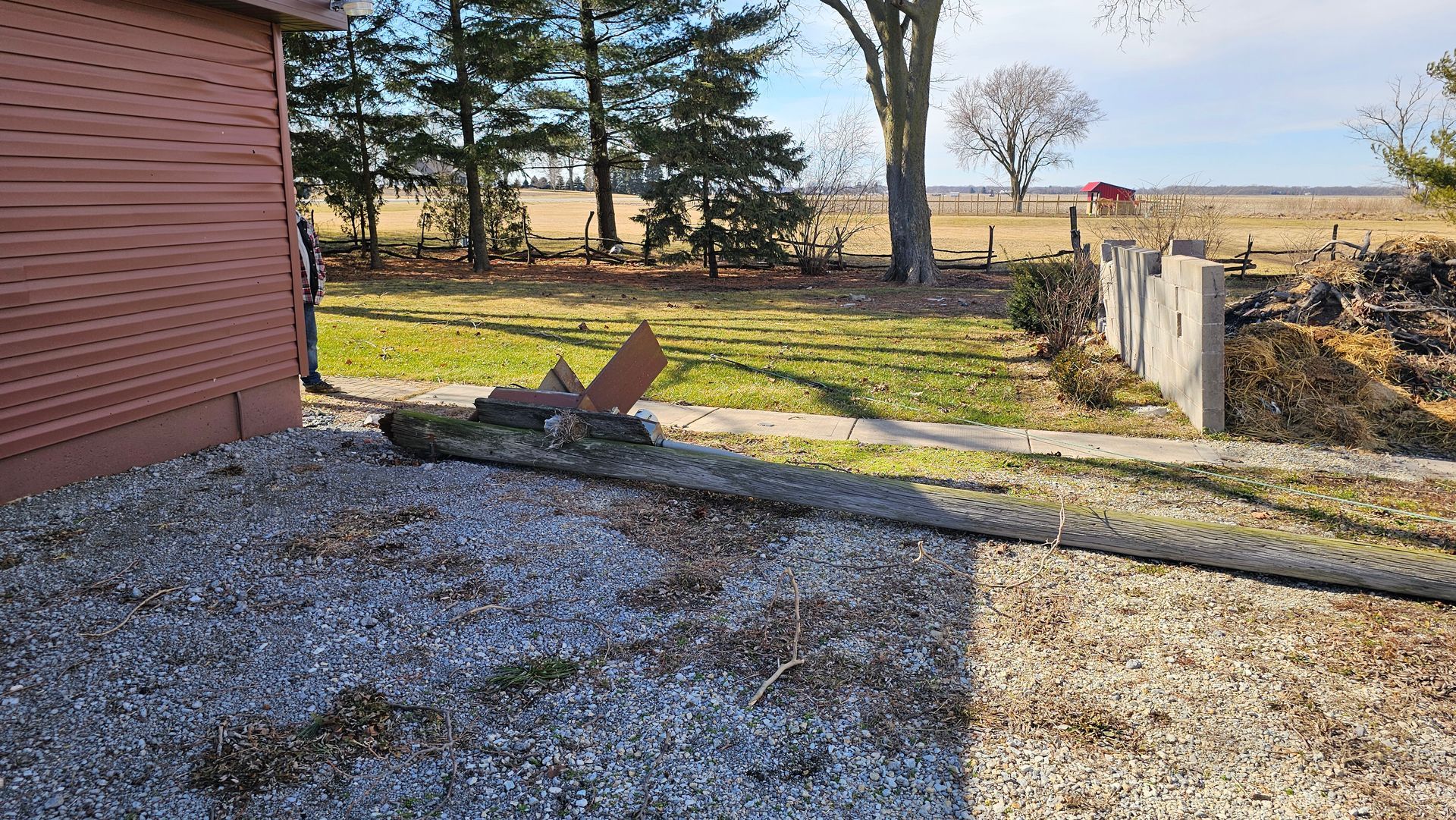 A tree is laying on the ground in front of a house.