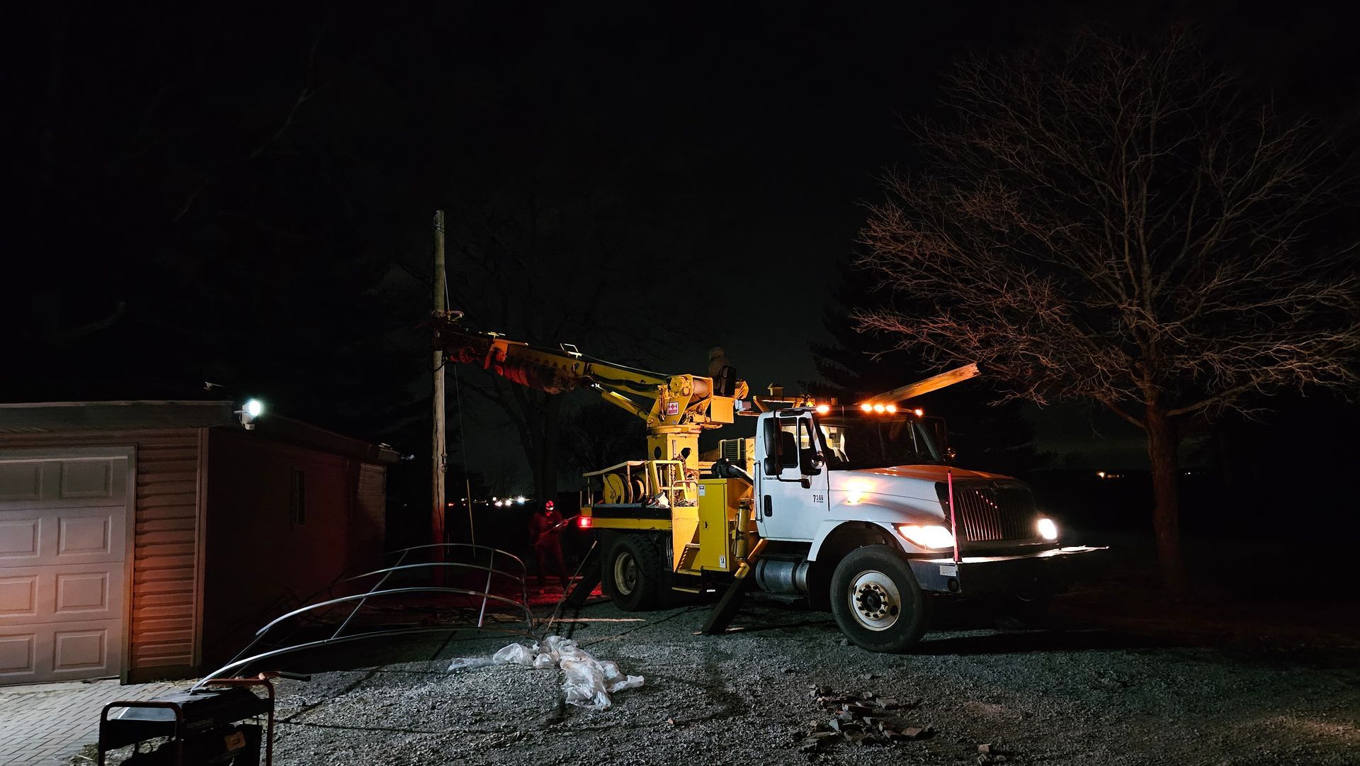 A truck is parked in front of a garage at night.
