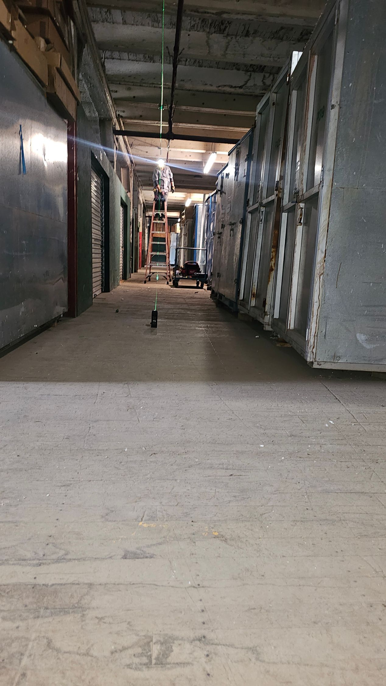 A long hallway in a building with a lot of boxes on the floor.