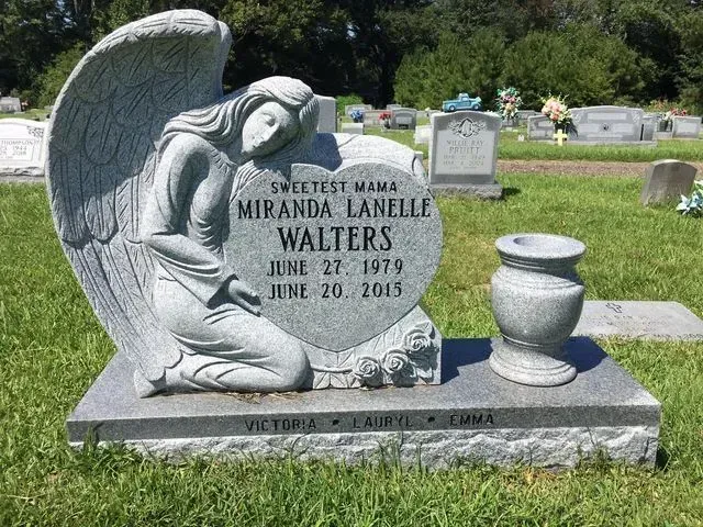A Gravestone in a Cemetery with a Statue of an Angel kneeling down – Canton, MS – Davidson Marble & Granite