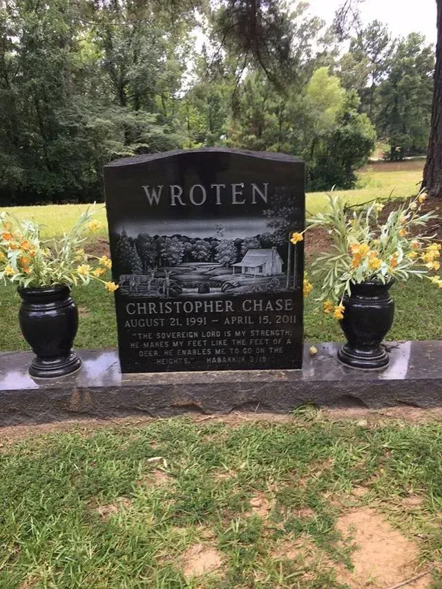 A Black Gravestone with two Vases of Flowers on it in a Cemetery – Canton, MS – Davidson Marble & Granite