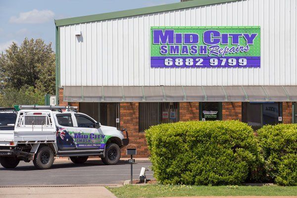 Mid City Smash Repairs Sign on Building With a White Truck Parked in Front — Mid City Smash Repairs in Dubbo, NSW