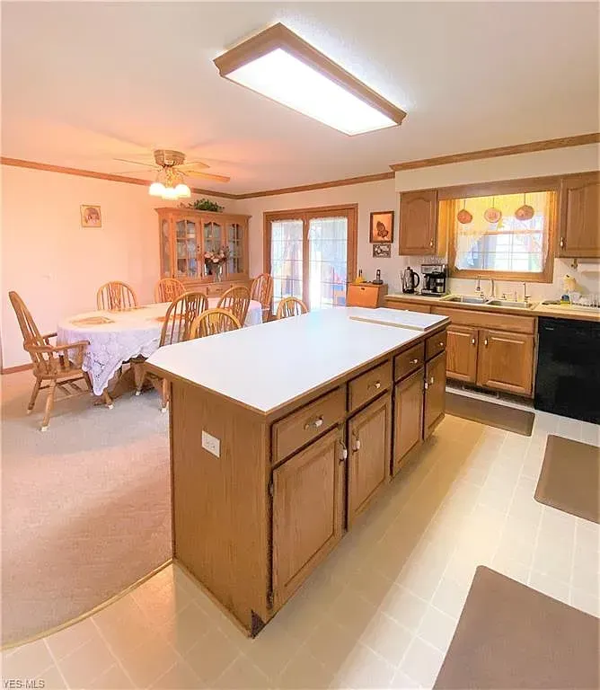Kitchen with island, dining area, and wood cabinets. Bright, neutral tones with natural light.
