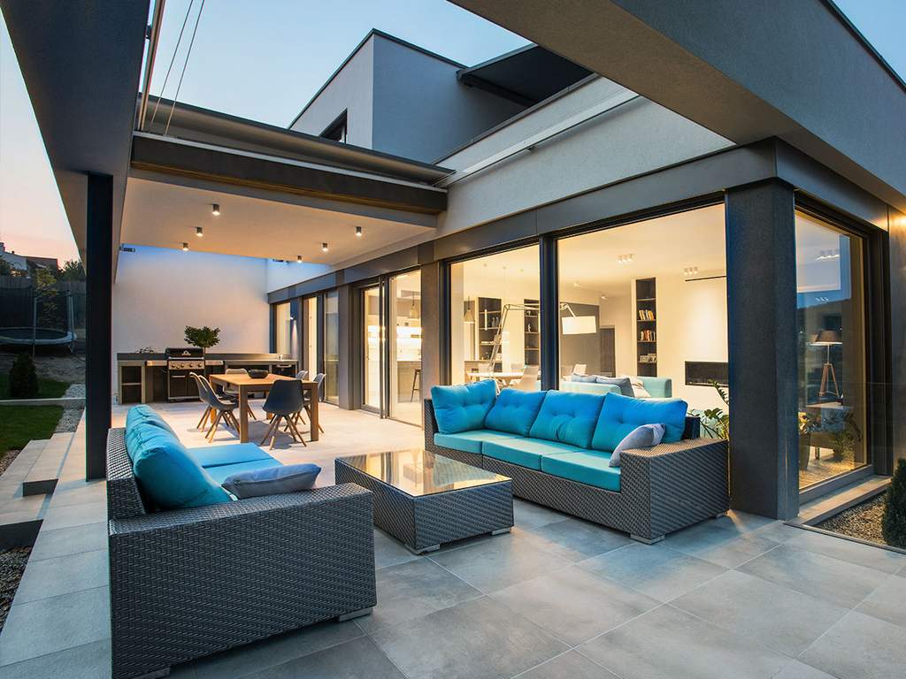 interno di una sala con tavolini e divani, circondata da finestre di vetro