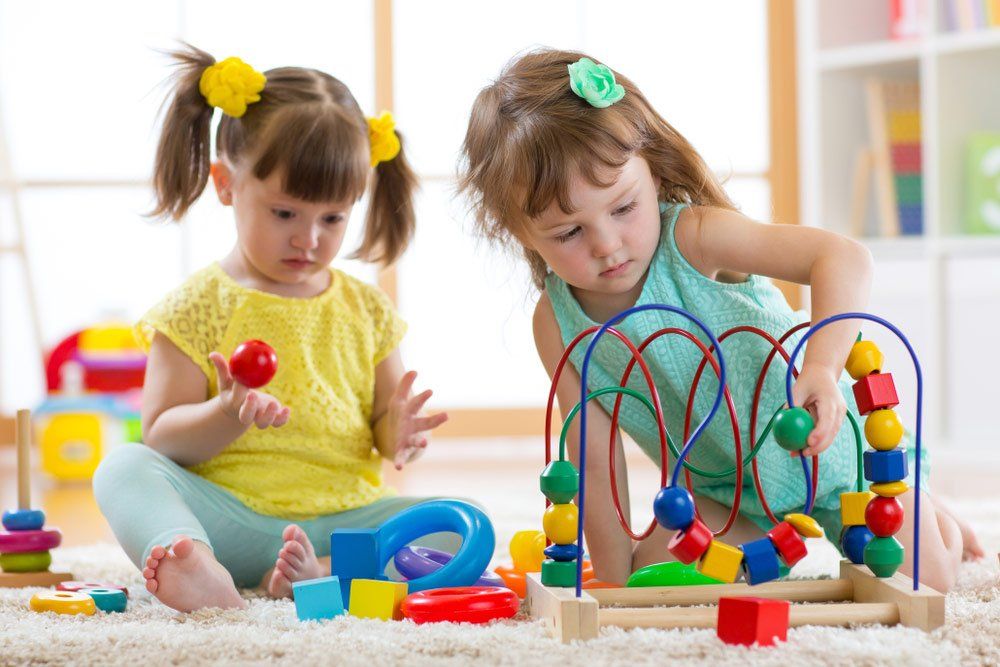 Two Kids Playing With Wooden Blocks In Their Nursery Room — Grandma Rosie’s Quality Long Day Care In Wollongong, NSW