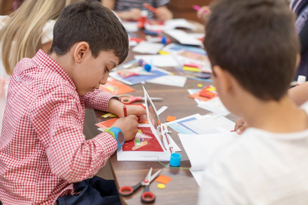 Young Boy Doing School Project Together With Other Kids — Grandma Rosie’s Quality Long Day Care In Wollongong, NSW