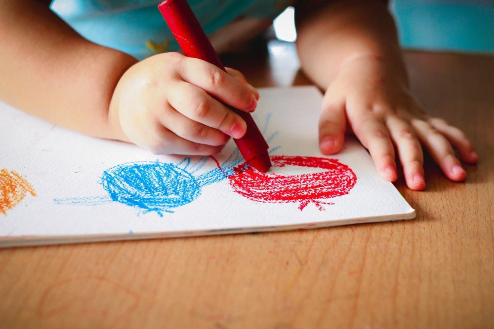 Cute Girl Drawing With Colourful Crayon — Grandma Rosie’s Quality Long Day Care In Wollongong, NSW