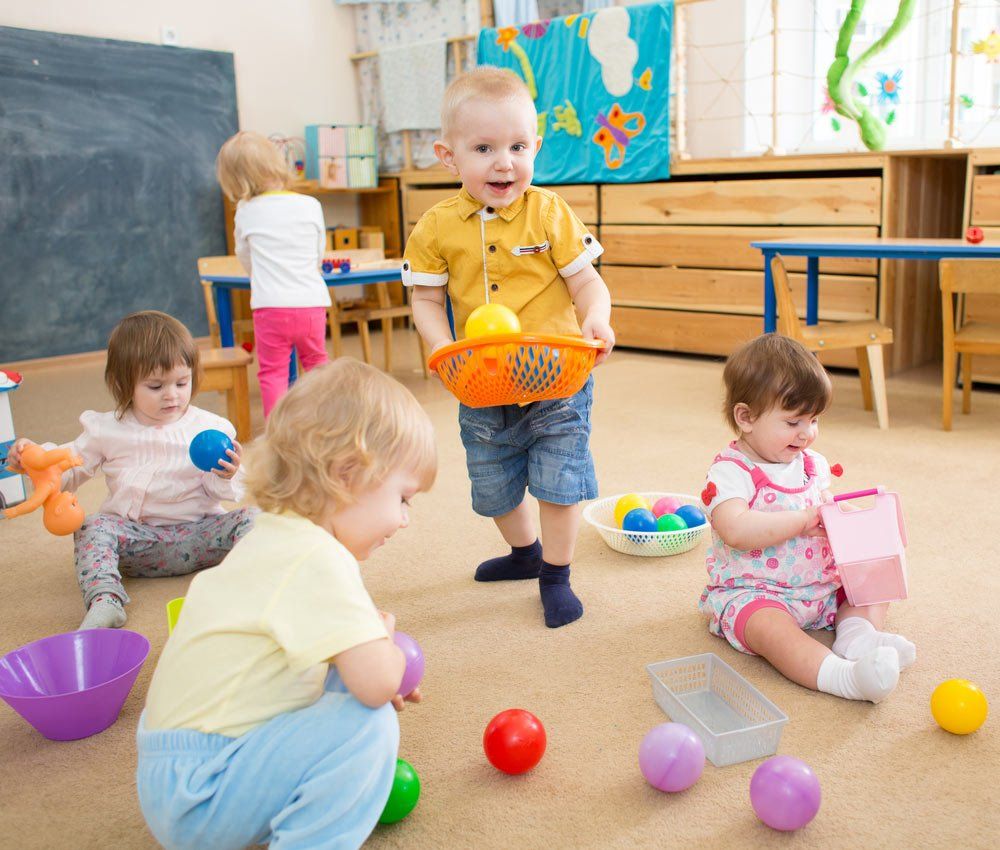 Kids Playing With Balls In Kindergarten Room — Grandma Rosie’s Quality Long Day Care In Wollongong, NSW