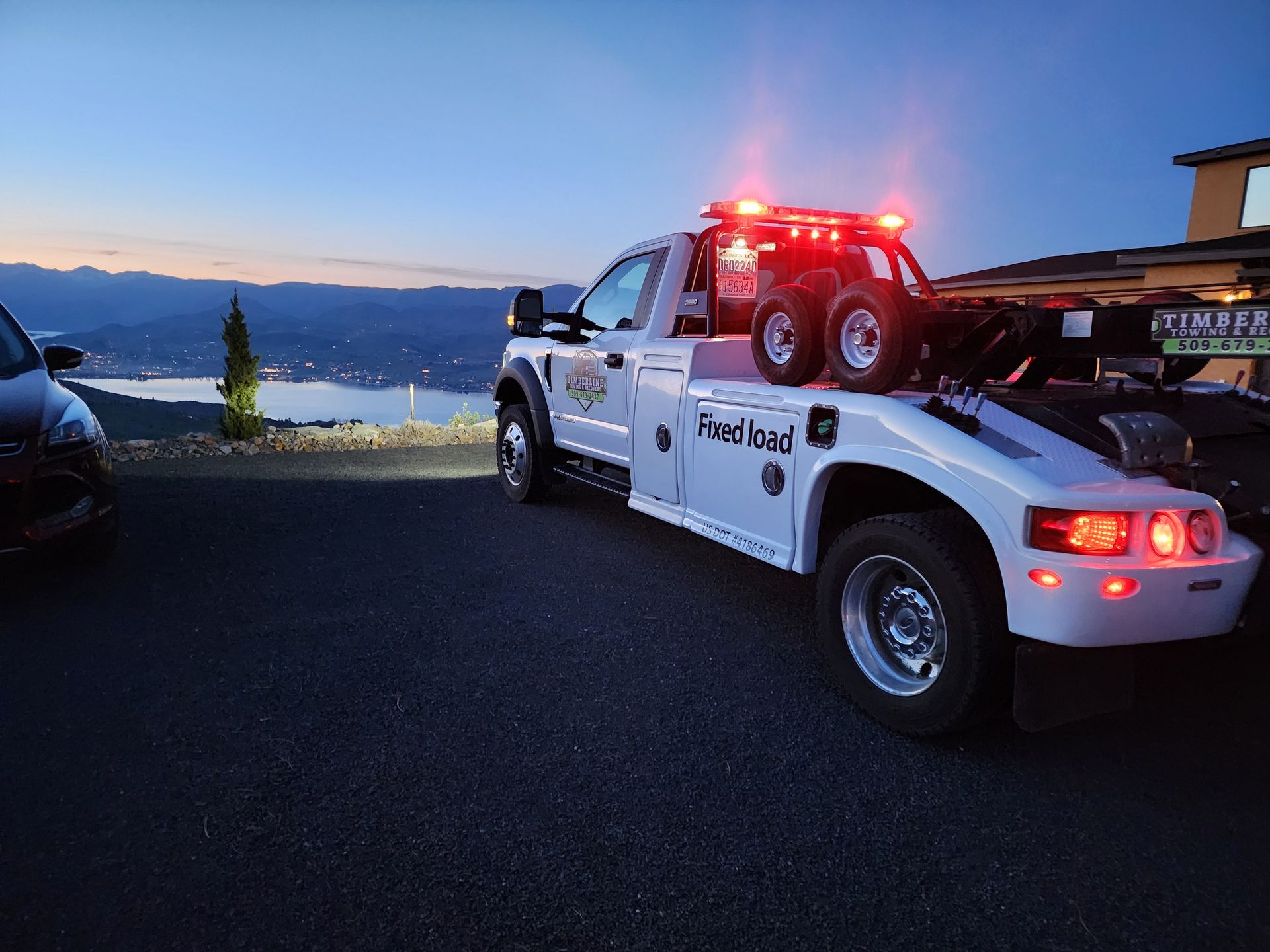 A tow truck is towing a car in a parking lot