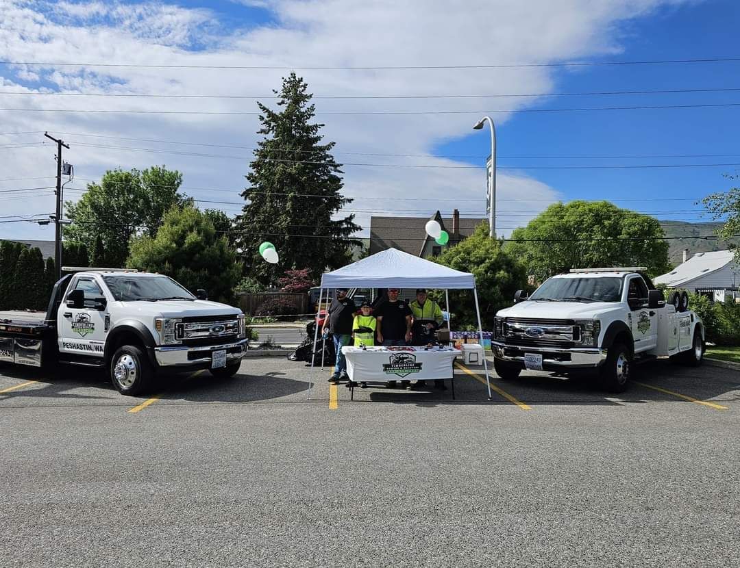 Two tow trucks are parked next to each other in a parking lot.
