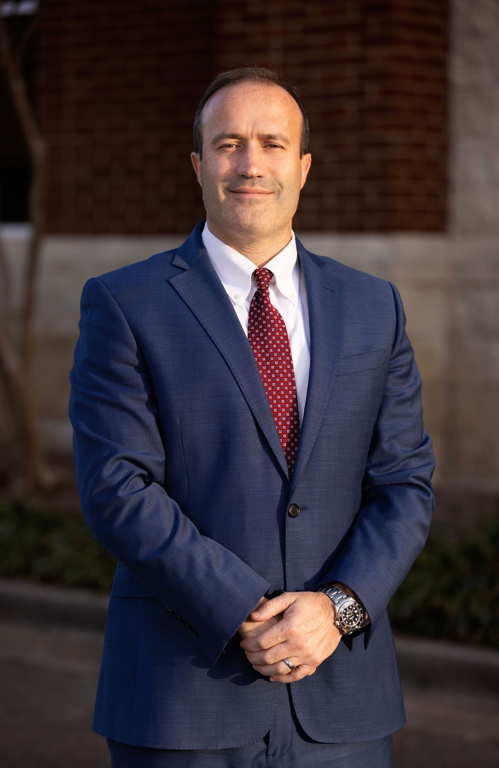 A man in a suit and tie is smiling for the camera.