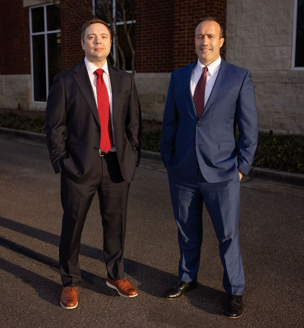 Two men in suits and ties are standing next to each other