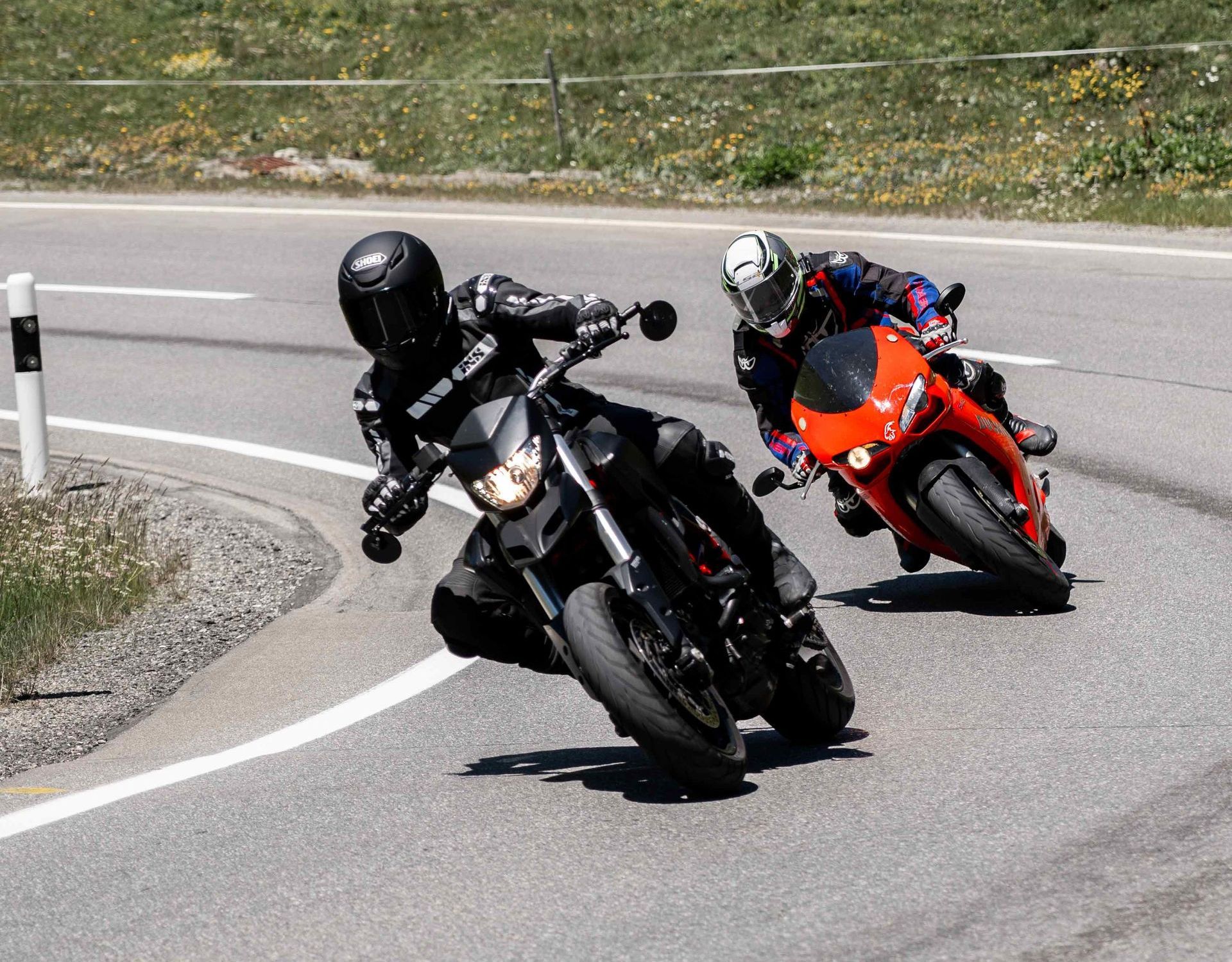 Zwei Männer fahren mit Motorrädern über den Julierpass in den Schweizer Bergen.