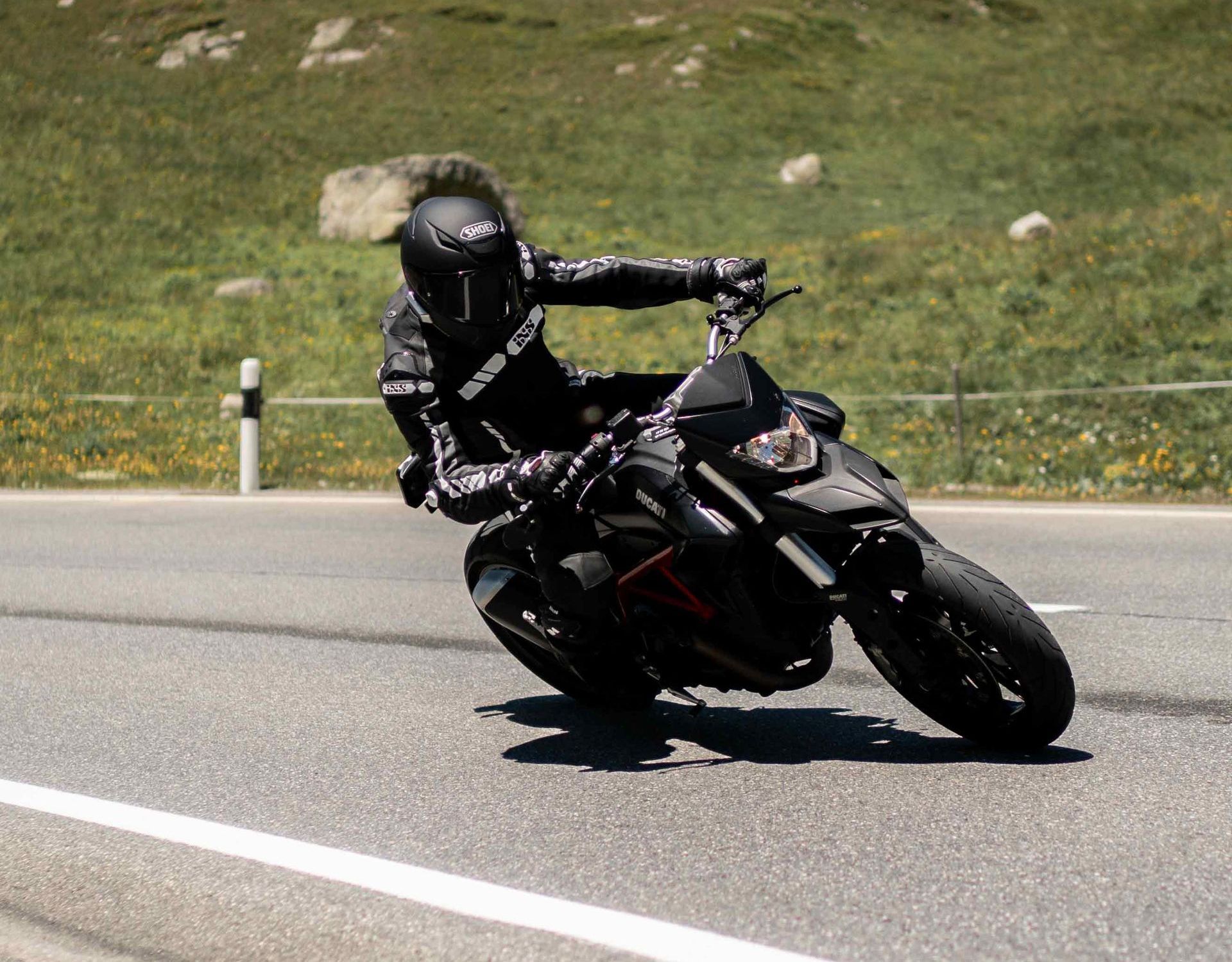 Ein Mann fährt mit einem Motorrad über den Julierpass in den Schweizer Bergen.