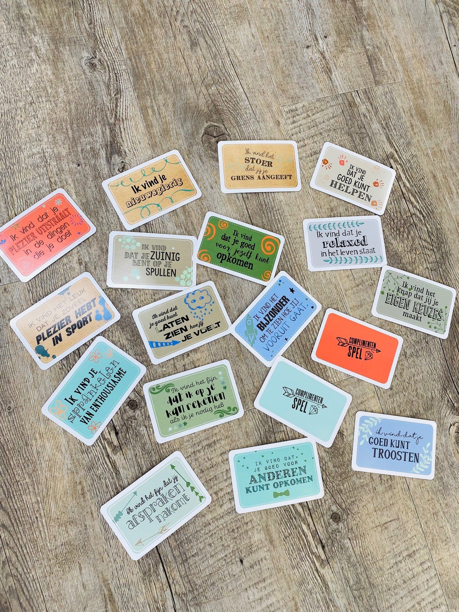 Verspreide rechthoeken met tekst, in verschillende kleuren en lettertypen, op een ondergrond met houtnerfstructuur.