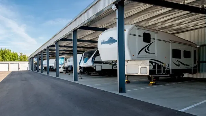 A row of rvs are parked under a covered area.