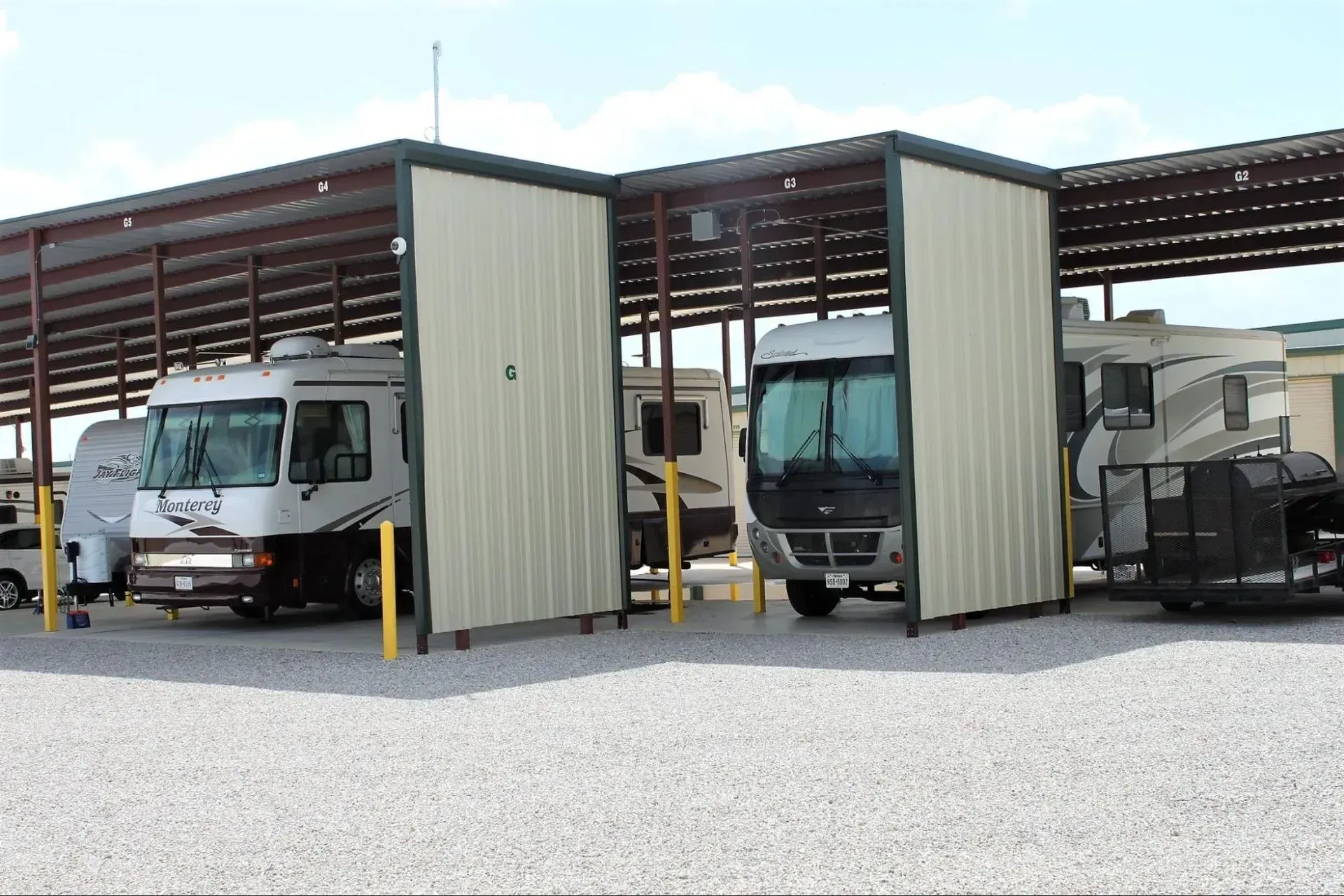 A row of rvs are parked under a covered area