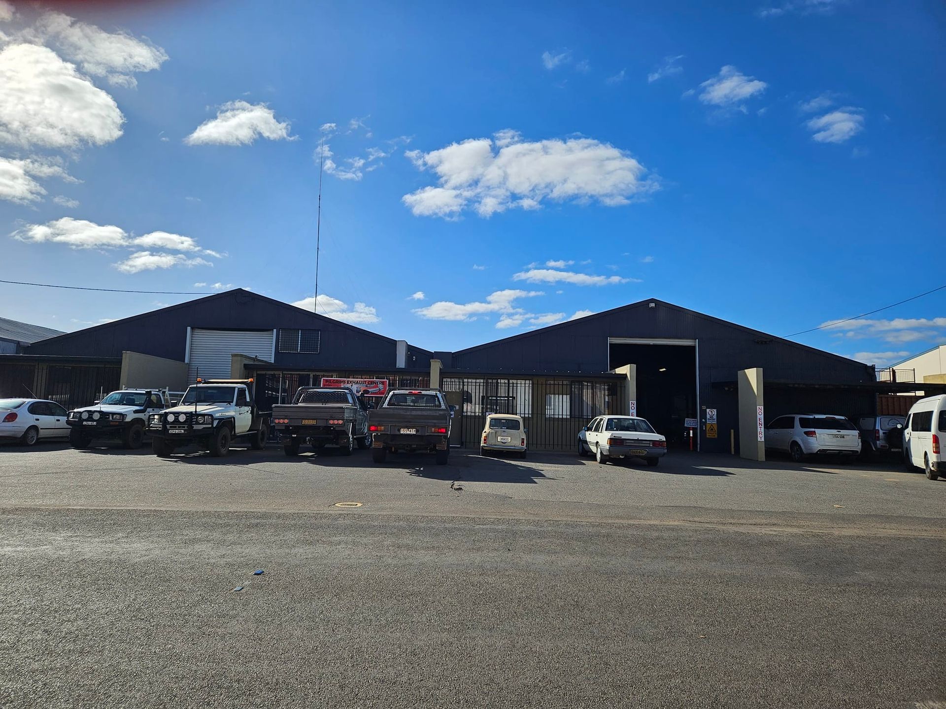 A bunch of cars are parked in front of a building.