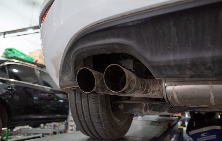 A man is working on the underside of a car.