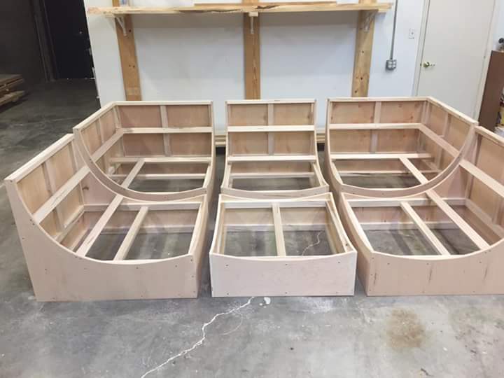 Three wooden frames are sitting on a concrete floor.