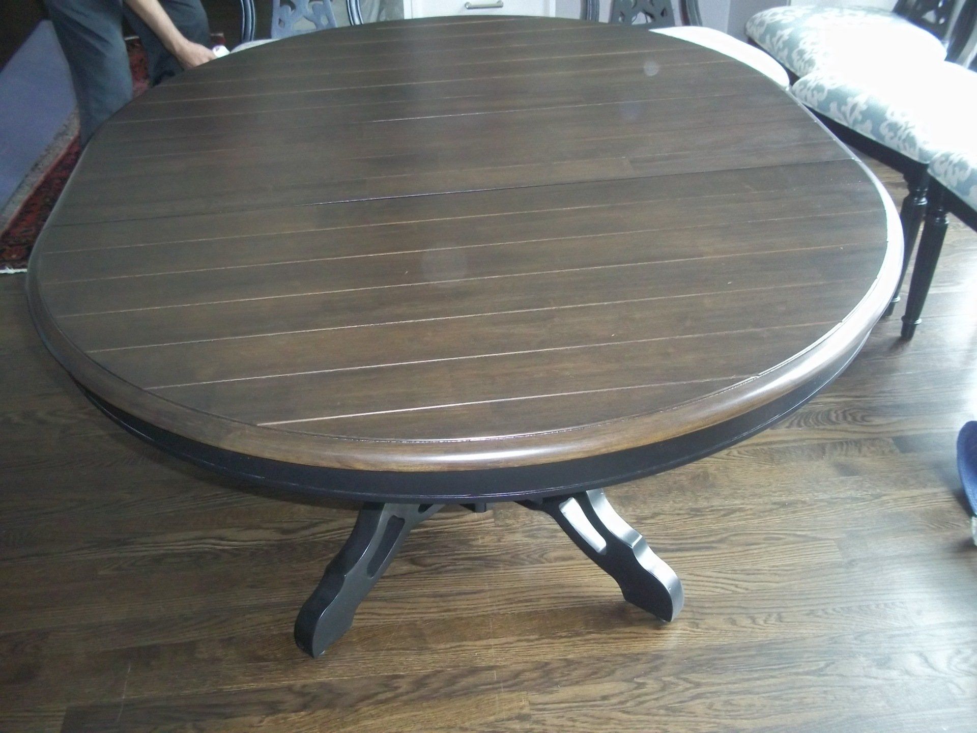 A round wooden table is sitting on a wooden floor