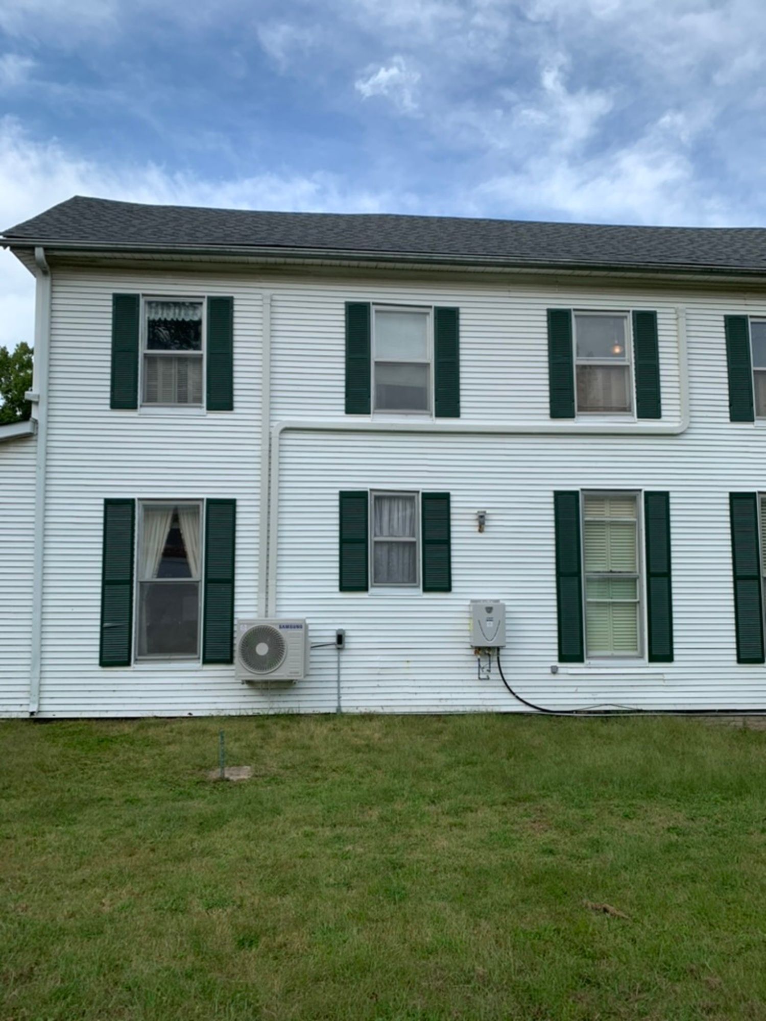 A white house with green shutters on the windows