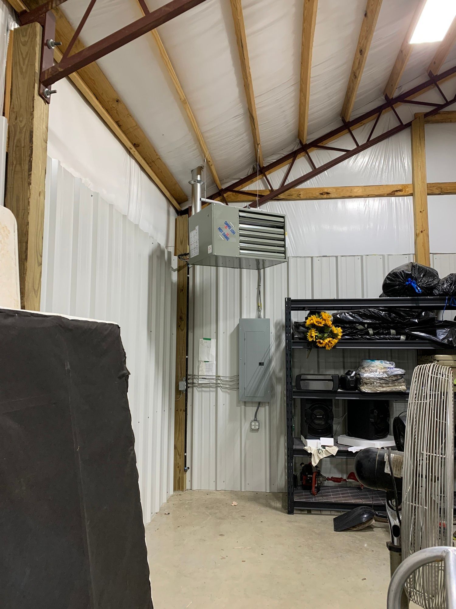 The inside of a garage with a heater hanging from the ceiling.