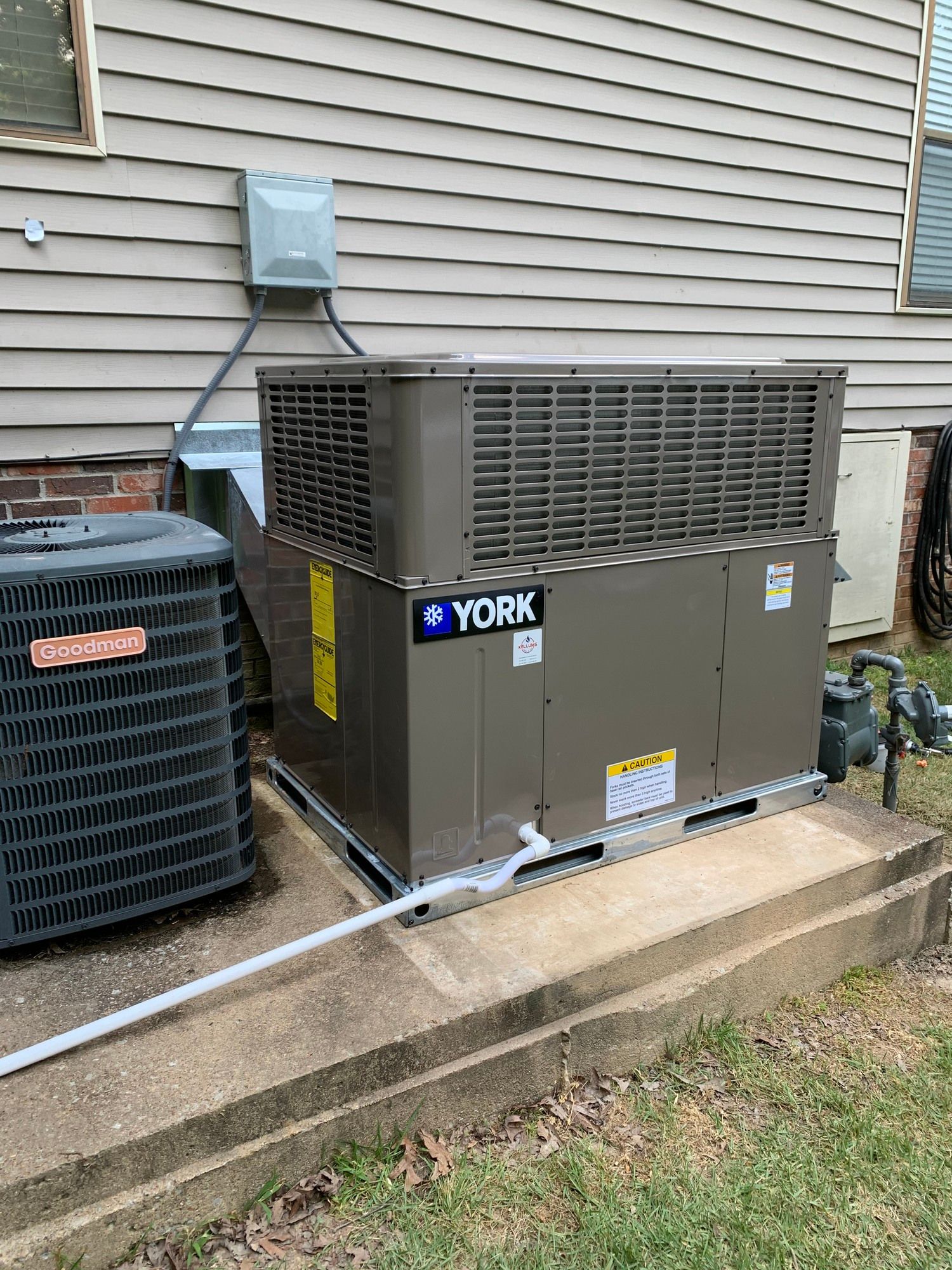 A york air conditioner is sitting on the side of a house.