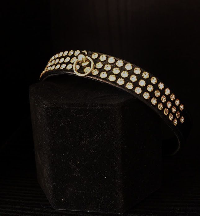 A black belt with gold studs sits on a black cube