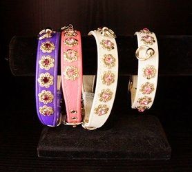 Three bracelets with flowers on them are on display