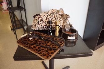 A table with a leopard print bag and lipstick on it