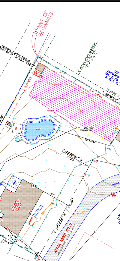 An aerial view of a residential area with a pond in the middle.