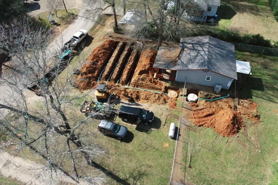 An aerial view of a house under construction with a lot of dirt in front of it.